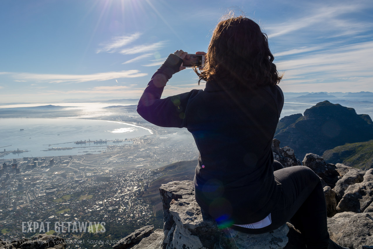 Don't drop the phone! Jess taking photos of the breathtaking view from Table Mountain, Cape Town. Expat Getaways Expat Getaways One Week in Cape Town.