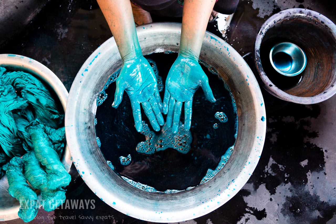 A textile workers hands in between runs dying silk at a textile shop in Inle Lake, Myanmar. 