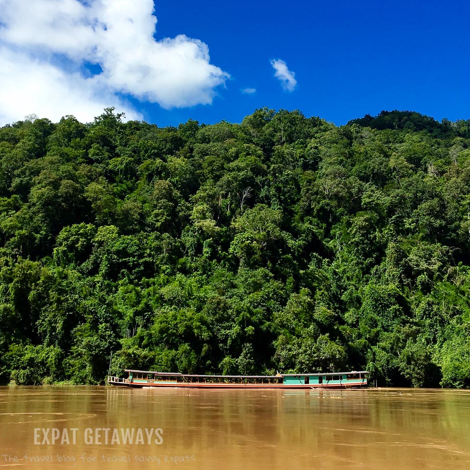 A river boat motors along the Mekong River. Luang Prabang, Laos. Expat Getaways, 48 Hours in Luang Prabang, Laos.