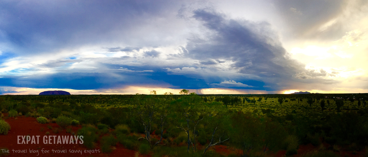 Watching the storms roll through the desert between Kata-Tjuta and Uluru from the top of a sand dune. Expat Getaways - Babymoon Destinations.